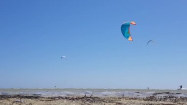 İnsanlar uçurtma sörfü yapıyor. Denizde kaykay yapmak. İnsanlar su üstünde sörf yapar.