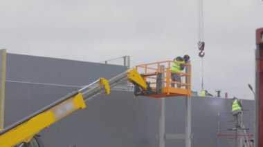 Asansördeki bir adam metal bir yapıya kaynak yapar. İnşaat alanında iş akışı. Metal kaynaklama