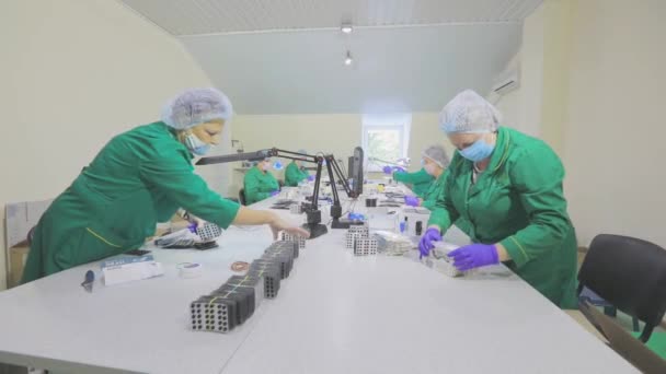 Women pack pills in a package. Factory workers wearing masks. work during a pandemic — Stock Video