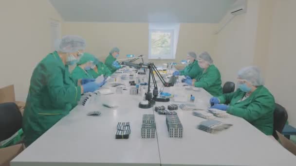 Factory workers pack pills. Masked workers. Workflow at a pharmaceutical factory — Stock Video