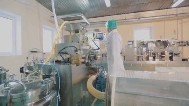 Gemaskerde mensen werken in een fabriek. Productieproces van geneesmiddelen. In de pil werkplaats. Het interieur van de farmaceutische fabriek. — Stockvideo