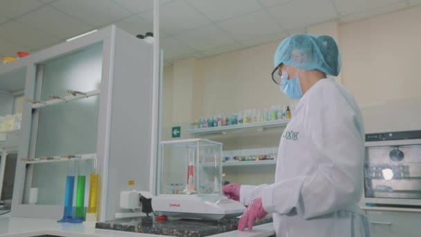 Werkstroom in het laboratorium. Een wetenschapper voert experimenten uit in het laboratorium. Laboratoriumassistent met gekleurde kolven — Stockvideo