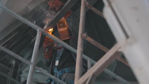 Närbild av en metallsvetsare. En svetsare arbetar på en byggarbetsplats. Svetsning av metalldelar — Stockvideo