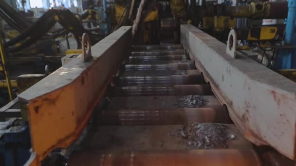 Metallo laminato in produzione, movimento su nastro di metallo caldo, fase di produzione di sfere, processo di produzione in un impianto di laminazione dei metalli, rotolamento attraverso rulli metallici scintillanti — Video Stock