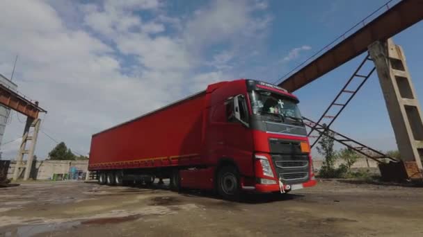 Un camion rouge avec une remorque rouge se rend à un entrepôt par une journée ensoleillée — Video