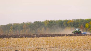 Yeşil traktör tarlayı sürüyor. Traktör sahada. Modern bir traktör tarlayı sürüyor..
