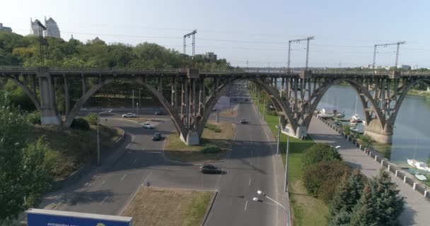 Le auto viaggiano lungo l'argine di una grande città. Imbarco sul fiume in una grande città. La strada lungo il terrapieno. — Video Stock