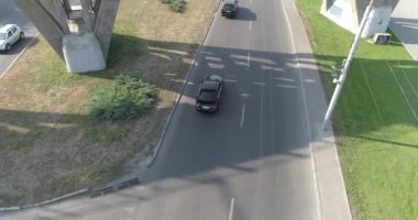 Şehrin üst manzarasında arabalar yol boyunca gider. Arabalar köprünün altından geçer. Köprü manzarasının altından geçen yolda birçok araba var. Araba trafiği.