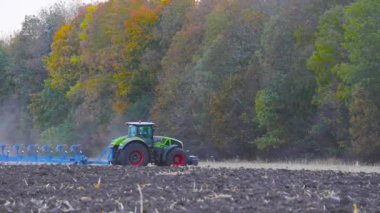 Traktör tarla sürüyor. Alanı bir traktörle işliyor. Traktör alanı işliyor..