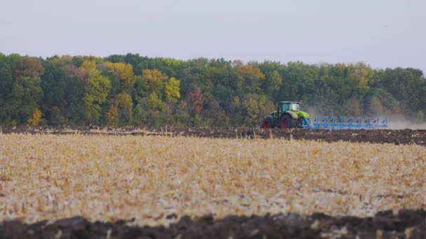 Ciągnik w terenie. Nowoczesny traktor zaorał pole. Zielony ciągnik pługa pole — Wideo stockowe