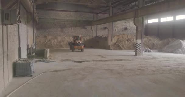 Gele bulldozer in een industrieel gebouw. Bulldozer op voorraad. Bulldozer duwt zand. — Stockvideo