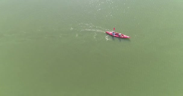 Menschen im Kanu auf dem See überfliegen. Kanu im See. Kanu mit zwei Personen schwimmt auf dem Flussgipfel — Stockvideo