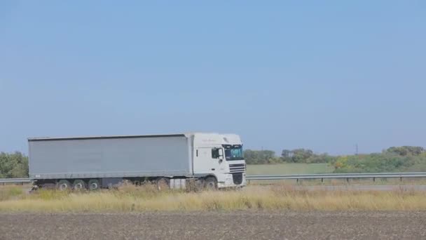 Il camion sta guidando sull'autostrada. Il camion guida sull'autostrada intorno ai campi e agli alberi — Video Stock