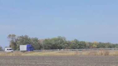 Vagon yazın güzel bir yol boyunca sürer. Bir araba mavi gökyüzüne doğru yol alır