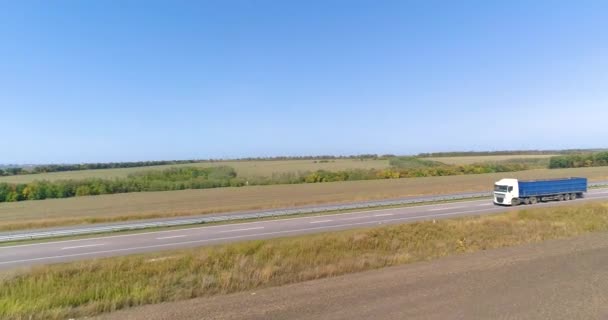 Camión conduce a lo largo de los campos en tiempo soleado. Camión conduciendo en una hermosa carretera. El camión conduce a lo largo de los campos vista superior. — Vídeo de stock