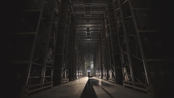 Mañana en la fábrica, un hombre camina a través de la luz del almacén se enciende — Vídeo de stock
