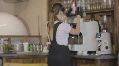 Barista bir kafede kahve yapar, şık bir kahveci, bir kafede çalışır.