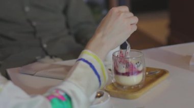 Kız yakın planda bir restoranda tatlı yiyor.