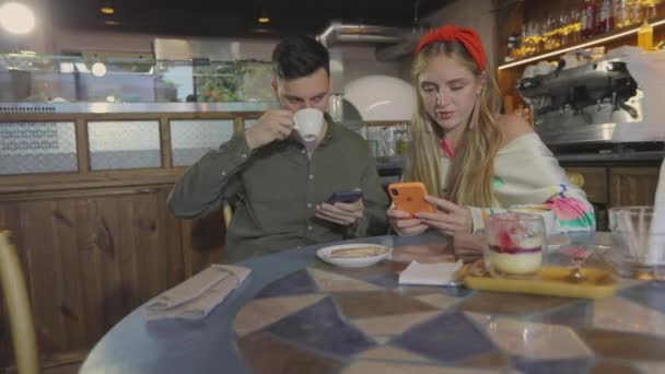 Fiatal pár randizik. Egy srác egy lánnyal egy kávézóban.. — Stock videók