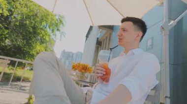 Gençler meyve suyu içer. Kız ve erkek meyve suyu içiyorlar. Meyve suyu restoranda bir masada.