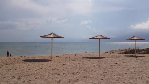 Ψάθινη ομπρέλα, άδεια παραλία. Ομπρέλες στην παραλία, ομπρέλες σε μια άδεια παραλία. — Αρχείο Βίντεο