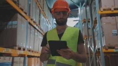 Bir adam ağır çekimde depodan geçiyor. Bir işçi ağır çekimde modern bir depoda yürüyor.