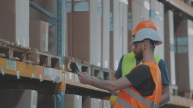 Depoda iki kişi bir şey tartışıyor. Modern bir depoda iki mühendis..