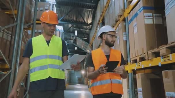Dva lidé ve skladišti o něčem diskutují. Dva inženýři v moderním skladu. — Stock video