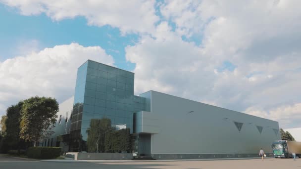 Edificio de oficinas con grandes ventanales de cristal. Un camión conduce hasta un edificio moderno. Camión cerca de un moderno edificio de oficinas — Vídeo de stock