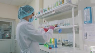 Renkli mataralı laboratuvar asistanı. Bir bilim adamı laboratuvarda deneyler yapıyor. Laboratuvarda çalışma akışı.