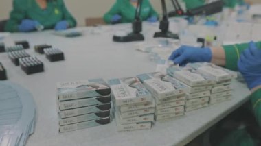 Maske takan fabrika işçileri. Salgın sırasında çalışmak. Kadınlar bir pakette hap paketler. Maske takan fabrika işçileri. bir salgın sırasında çalışmak