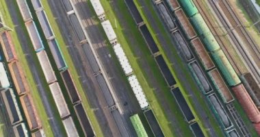 Güneşli havada demiryolu kavşağı, üst manzara. Tren istasyonunun üst manzarasındaki yük trenleri. Demiryolu kavşağındaki yük trenleri