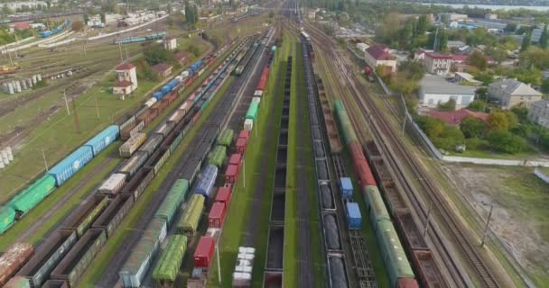 Los trenes de colores se encuentran en un gran depósito ferroviario. Gran depósito de trenes. Enlace ferroviario con una gran cantidad de rieles vista superior. — Vídeo de stock