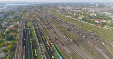 Tren istasyonunun üzerinden uçuş. İstasyondaki yük trenleri. Büyük endüstriyel demiryolu deposu manzarası.