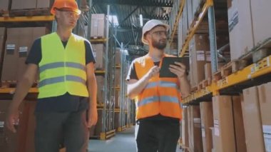 Depoda iki kişi bir şey tartışıyor. Modern bir depoda iki mühendis..