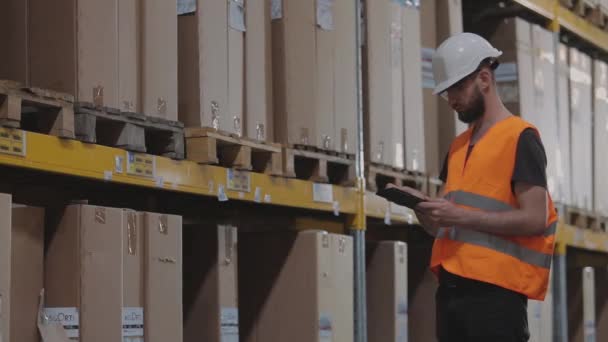 Pracovník s tabletem v moderním továrním skladu — Stock video
