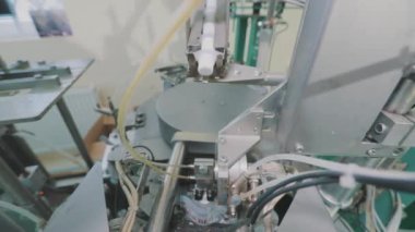 Krema paketleme tüpleri yakın çekim. Paketleme yakın plan. Tüplere krem paketlemek için otomatik makine.