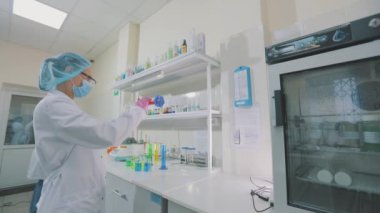 Renkli mataralı laboratuvar asistanı. Bir bilim adamı laboratuvarda deneyler yapıyor. Laboratuvarda çalışma akışı.