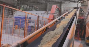 Fabrikada taşıma bandı hattı, kum ve metal toplarla taşıma bandı.