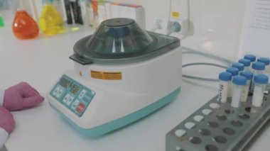 Bir bilim adamı laboratuvarda deneyler yapıyor. Laboratuvarda iş akışı. Renkli mataralarla laboratuvar asistanı.