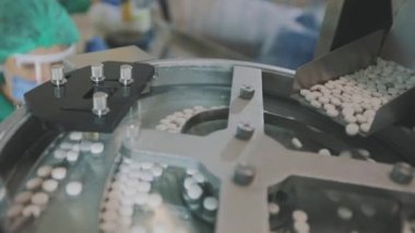Yakın çekim tablet üretimi. İlaç fabrikası. Tablet üretimi için taşıma hattı