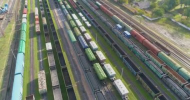 Büyük tren deposu manzaralı. Demiryolu istasyonunda bir sürü renkli tren var.