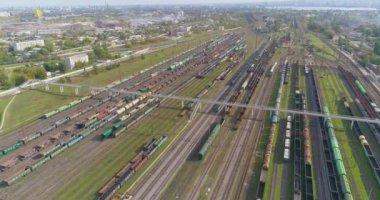 Büyük endüstriyel tren istasyonu. Trenler demiryolu kavşağındaki istasyona park edilmiş. Birçok renkli tren