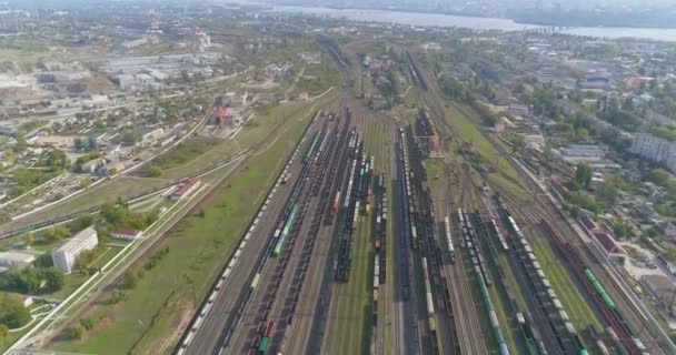 Enlace ferroviario con una gran cantidad de rieles vista superior. Trenes de colores se encuentran en un gran depósito ferroviario — Vídeos de Stock