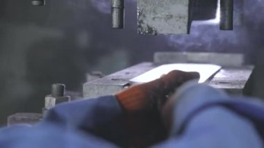 Makinenin bir parçasını bükmek. Makinede metal bir parça damgalanıyor.