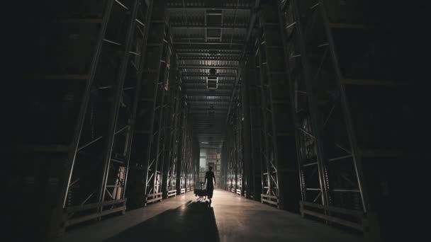 Pagi di pabrik, seorang pria berjalan melalui lampu gudang menyala. Menyalakan lampu di gudang pabrik — Stok Video