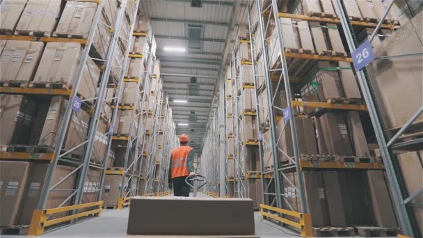 Zhasínám světla ve skladišti. Konec pracovního dne v továrně. Muž v oranžové vestě nosí krabice ve skladišti. — Stock video