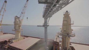 Denizden nakil için bir kargo gemisine tahıl yüklemek. Gemi limanda buğdayla dolu. Buğday ihracatı. Deniz ihracatı. Tarım