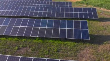 Güneş Panelleri Çiftliği 'nin güneş ışığı alan havadan görüntüsü. İnsansız hava aracı güneş panelleri alanının üzerinde uçuyor. Yenilenebilir yeşil alternatif enerji