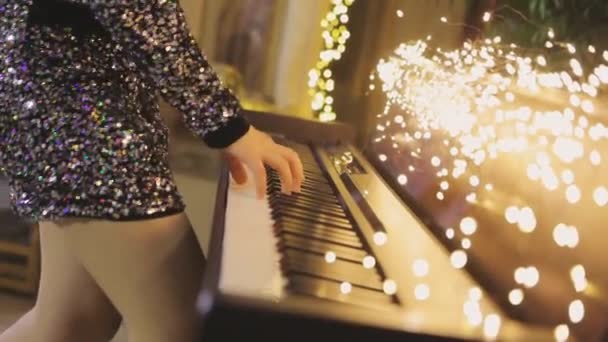 Руки грають синтезатор. Жінка грає синтезатор в інтер'єрі Нового року. Відтворення синтезатора — стокове відео